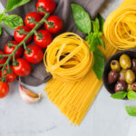 Italian food ingredients with pasta, tomatoes, cheese, olive oil, basil